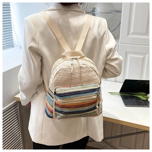 Rear view of model wearing woven crossbody bag with colorful stripes and beige straps