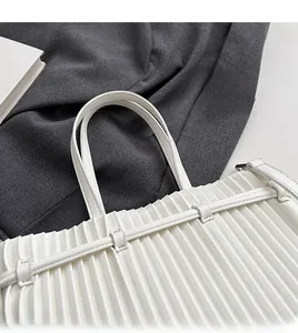 Close-up of white pleated PU leather handbag handle with silver metallic buckle detail