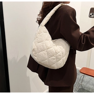 Model view of a white quilted nylon hobo cloud bag with textured diamond stitching