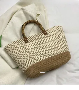 Detail of woven tote bag featuring bamboo handles and beige-brown patchwork texture
