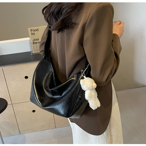 Borsa hobo nera in similpelle lucida con ciondolo a orsetto di peluche bianco e trama naturale