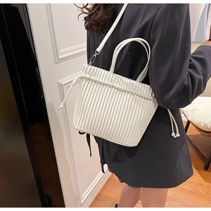 Detail of white PU leather handbag with elegant vertical pleats and drawstring accent