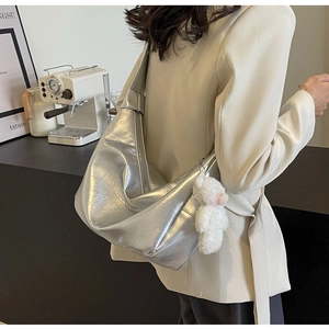 Elegante borsa hobo argento con ciondolo a forma di orsetto su modella in stile urbano