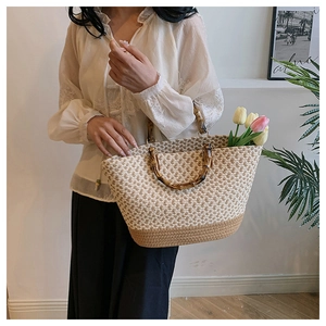 Detailed close-up of handmade woven tote bag with natural bamboo handle and metal rings