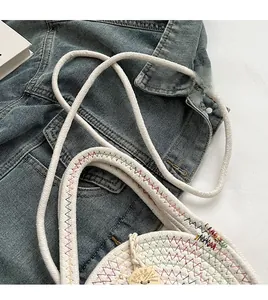 Detail of white woven bag featuring rainbow wavy stitching and durable cotton rope handles