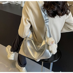 Dettaglio della borsa a tracolla argento metallizzato con ciondolo a forma di orsetto