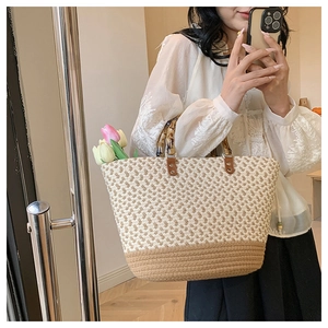 Detail of woven tote bag with bamboo handle and dual-tone beige brown texture