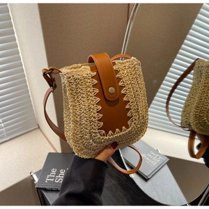 Chic woven straw crossbody bag with brown faux leather strap and round metal buckle detail