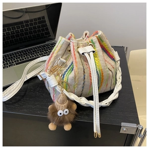 Rainbow striped woven bucket bag with white drawstring and a cute monster pendant