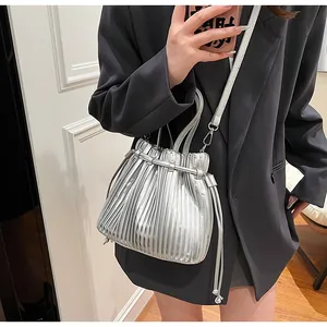 Detail showing metallic silver pleated bucket bag with reflective mirror finish texture