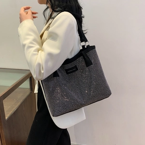 Detailed view of black rhinestone tote bag showing the canvas texture and metal rings