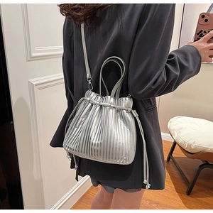 Detailed view of silver pleated PU handbag with metallic texture and crossbody strap