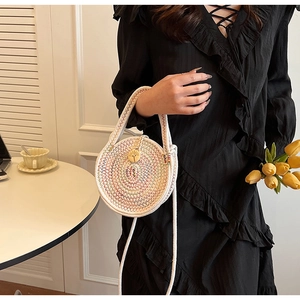 Detail of a woven cotton linen crossbody bag with colorful stitching and wooden button decor