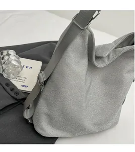 Detail of adjustable gray fabric strap and metallic buckle on silver glitter handbag