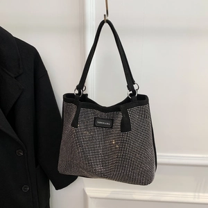 Detail view of black fashion handbag with silver rhinestones and metal ring strap connectors