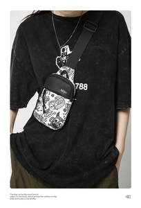 Détail du sac de poitrine en nylon avec graffiti de monstre noir sur tissu blanc