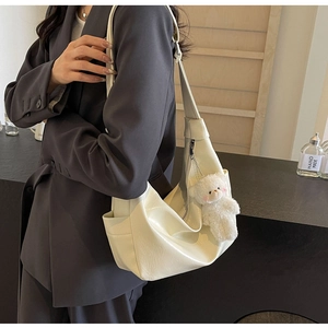 Dettaglio della borsa hobo in pelle PU bianco crema con ciondolo a forma di orsetto