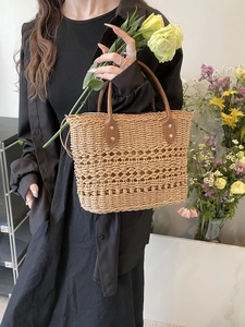 Detailed close-up of woven tote bag featuring hollow-out patterns and leather handles