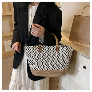 Close-up of woven tote bag with natural bamboo handles and stylish zigzag pattern