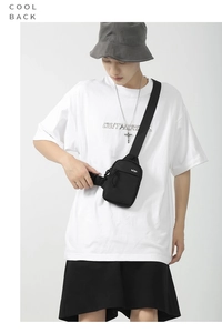 Close-up of minimalist black water-resistant nylon crossbody chest bag with adjustable strap