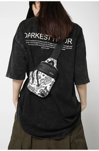 Photo street style d'un sac de poitrine en nylon à graffiti monstre noir et blanc