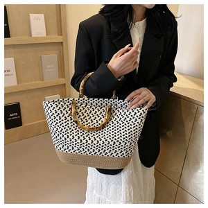 Detail of hand-woven tote bag with geometric pattern and vintage bamboo handles