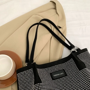 Close-up of black tote bag with shimmering silver rhinestones and fashion label detail