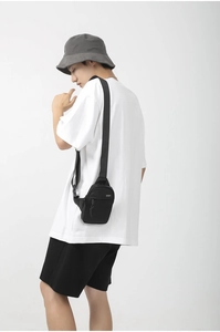 Detailed view of black nylon crossbody bag with adjustable strap and logo print