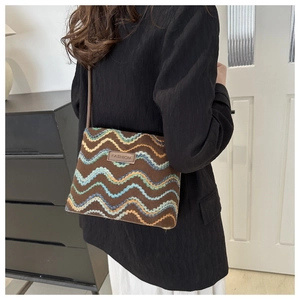 Detail of cross-body bag with multi-color wave embroidery and fashion leather patch