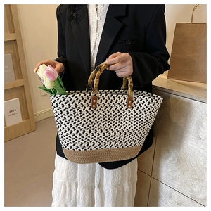 Detail of hand-woven tote bag showing bamboo handles and two-tone fiber texture