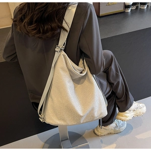 Close-up of stylish silver glitter PU tote bag with wide adjustable shoulder strap detail