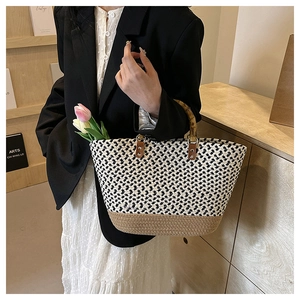 Close-up of woven tote bag featuring bamboo handle and contrast texture with flowers