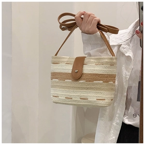 Detailansicht der gestreiften Strohtasche mit Ledergriff und Magnetverschluss für Damen