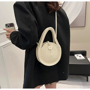 Detail of round woven cotton linen bag featuring spiral texture and wooden button closure
