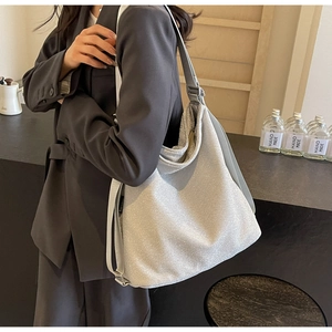 Modern silver glitter tote bag shown with adjustable grey strap and spacious soft structure