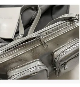 Detail of silver metallic textured fabric and smooth metal zipper on the crossbody bag