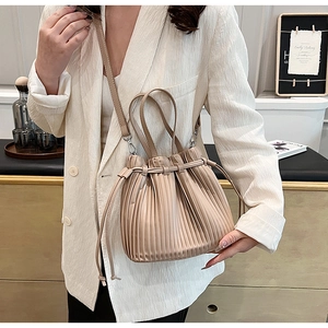 Chic beige pleated bucket bag styled with a white blazer for a trendy lifestyle look