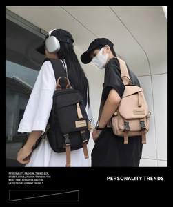 Detail shot of black and beige nylon chest bags with adjustable straps on models