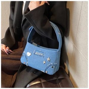 Détail du sac bandoulière en denim avec boucles en métal coeur et couture à franges