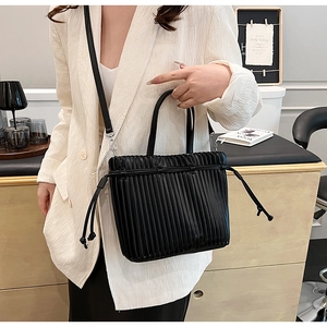 Detailed view of black pleated PU leather crossbody bag with drawstring closure