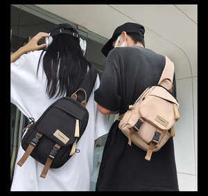 Close-up of durable nylon crossbody chest bags in black and khaki with adjustable straps
