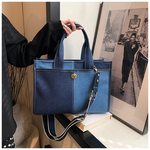 Detail of blue patchwork denim tote bag with gold twist lock and woven strap