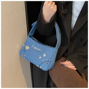 Détail du sac bandoulière en denim avec cœur, étoiles et rivets style Y2K