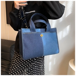 Detailed view of the blue denim patchwork tote bag with gold lock and beaded strap