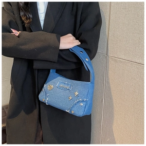 Détail du sac bandoulière en jean bleu avec rivets et patch vintage sur un mannequin