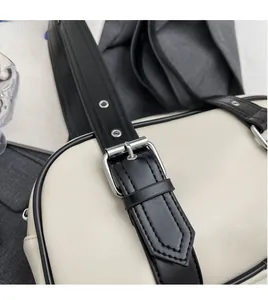 Detailed close-up of the black PU leather strap and silver buckle on the two-tone handbag