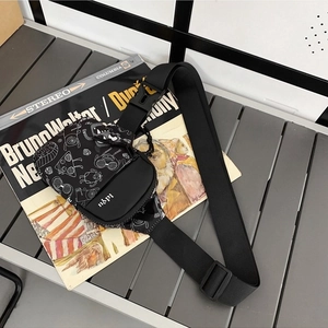 Sac bandoulière minimaliste en nylon noir avec imprimé graffiti monstre et large sangle