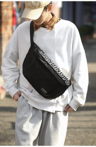 Détail du sac bandoulière en nylon noir avec lettrage blanc et sangle réglable robuste