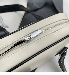 Detailed macro shot of silver metal zipper closure on off-white faux leather handbag
