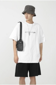 Close-up of a black minimalist nylon crossbody bag with zipper detail for summer casual style